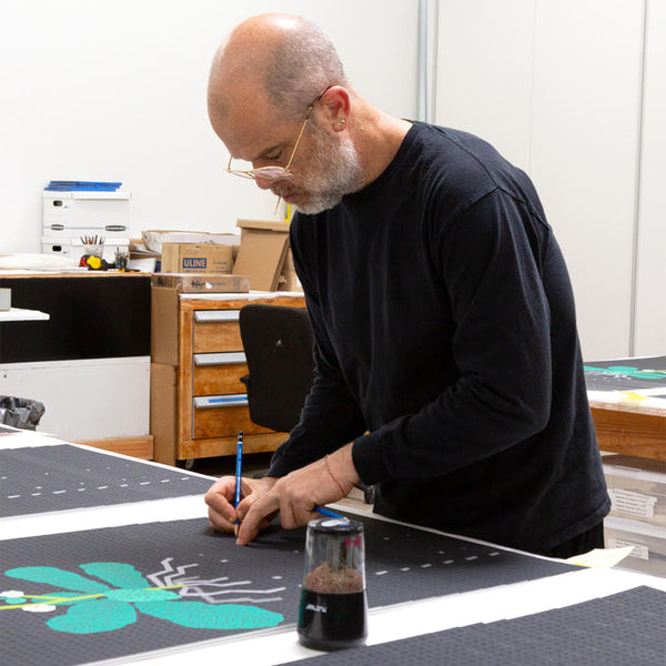 Image of Jonas Wood signing his White Flower with Grid print